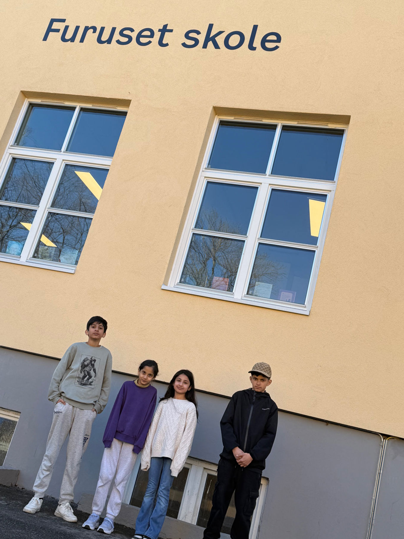 en gruppe mennesker som poserer for et bilde foran en bygning