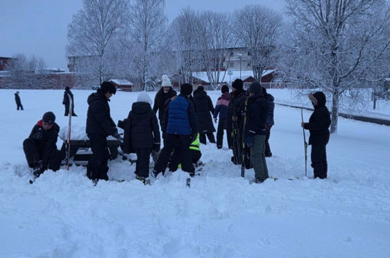 en gruppe mennesker som står i snøen