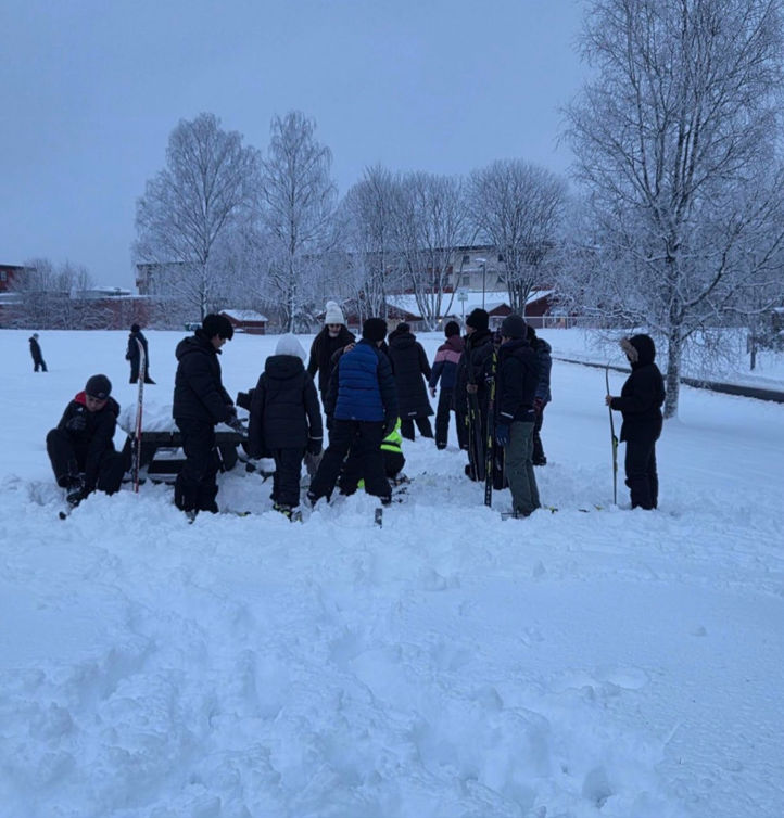 en gruppe mennesker som står i snøen