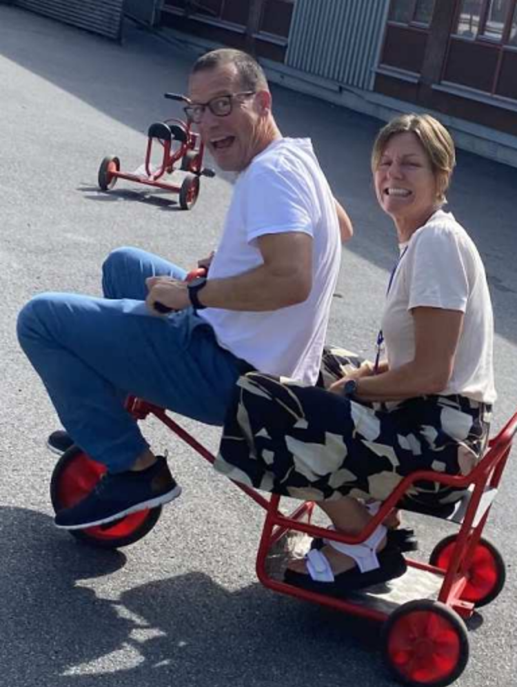 en person og en person som sitter på en rød og svart gressklipper